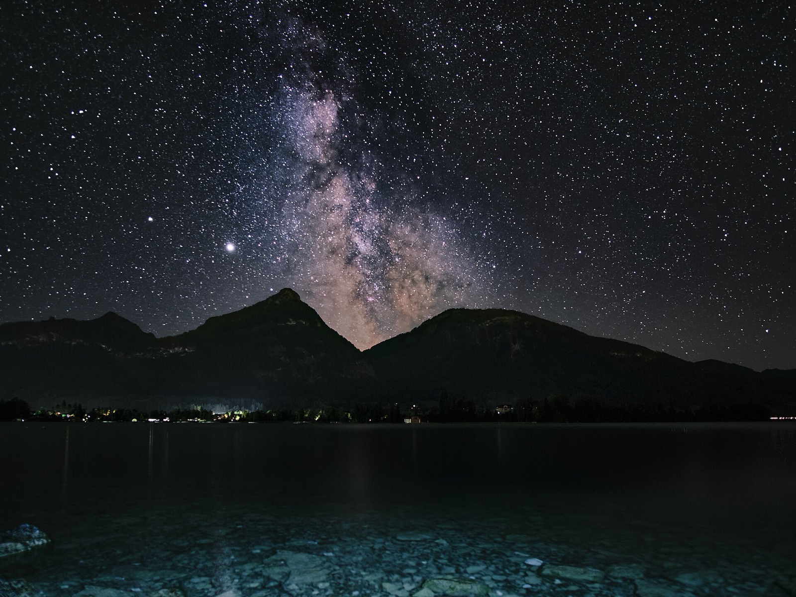 Milky Way above a dark landscape, made from stacked sky exposures and a separate foreground frame