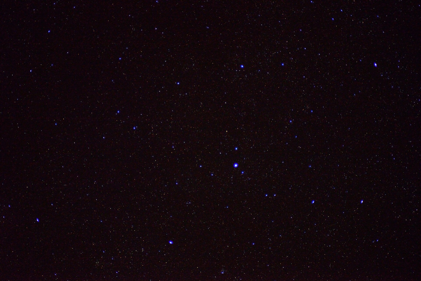 Grainy photograph of the stars of Cassiopeia on a speckled, noisy dark background.
