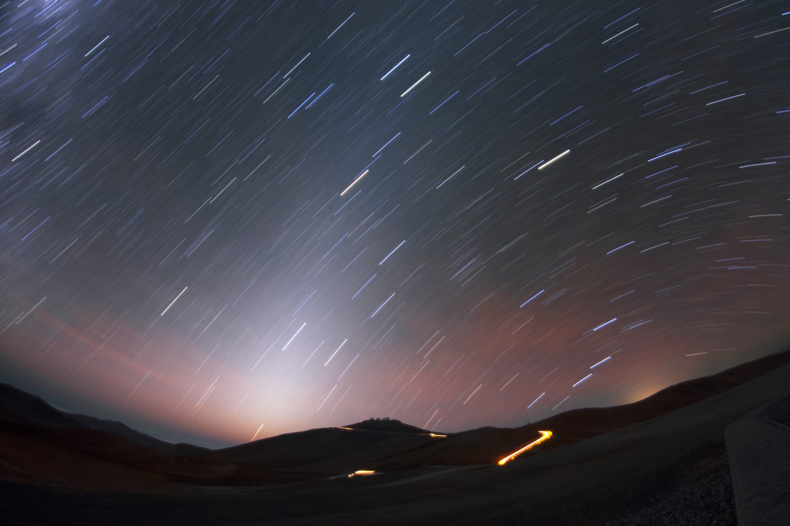 Soft cone of zodiacal light rising from the horizon into a starry night sky