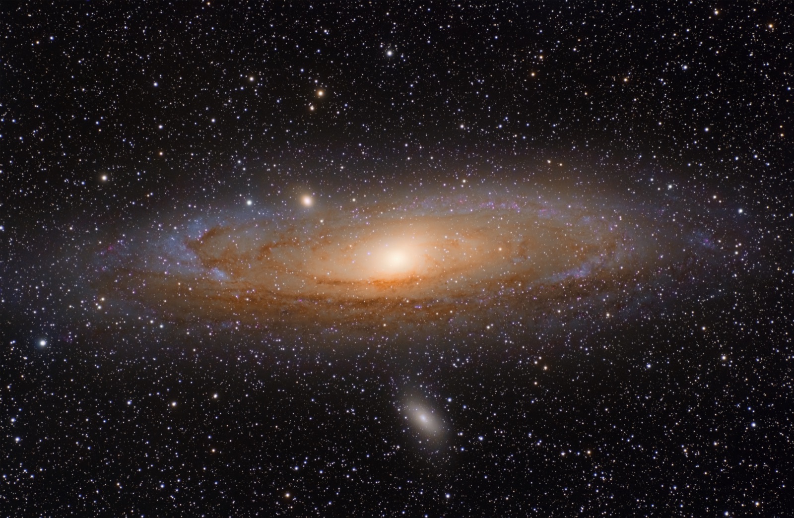 Spiral Andromeda Galaxy with a bright core and dust lanes, two small companion galaxies nearby.