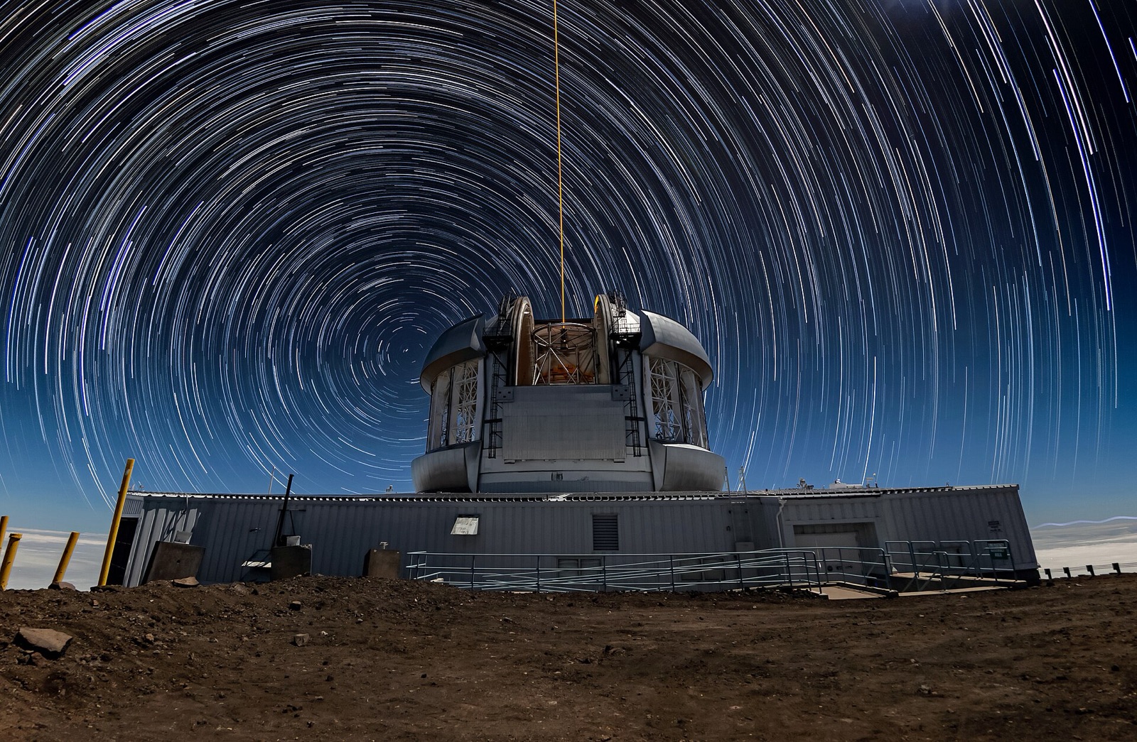 Concentric circular star trails over a silver observatory dome.